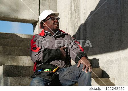 African american worker at project site has a stomachache, he touches his stomach 121242452