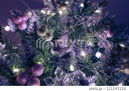 A close-up of a Christmas tree adorned with a delicate white dove ornament, symbolizing peace and hope. The dove is surrounded by soft pink and white baubles  A close-up of a Christmas tree adorned with a delicate white dove ornament, symbolizing peace and hope. The dove is surrounded by soft pink and white baubles  121243118