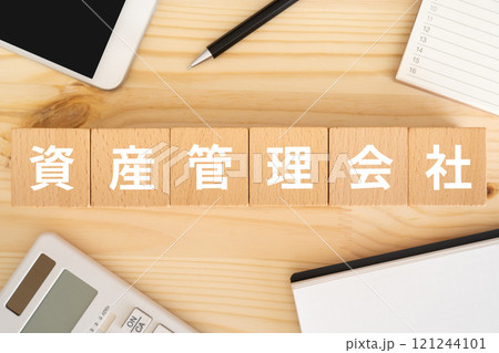資産管理会社の文字が入ったブロック、スマホ、電卓 121244101