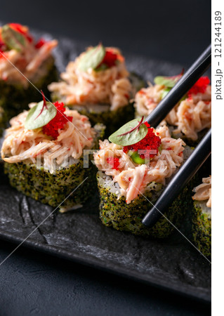 Japanese cuisine. Sushi rolls on a black platter 121244189