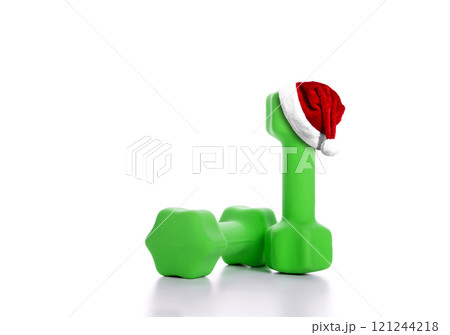 Santa hat on green dumbbells on white background 121244218