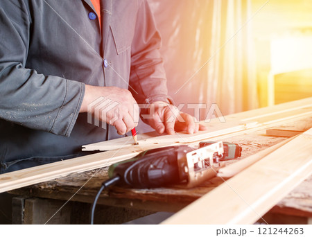Measuring wooden slot and key boards and drawing with pencil line 121244263