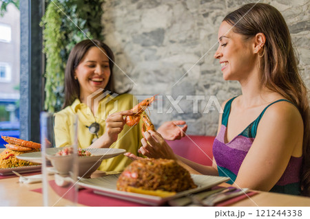 Women eating shrimps in ecuadorian restaurant in madrid 121244338