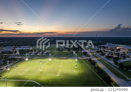 Public sports stadium with young people playing football game at sunset. Active way of life concept 121245090