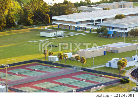 Public school in USA with school kids playing American football game on campus sports stadium at sunset. Physical exercise education in the United States Public school in USA with school kids playing American football game on campus sports stadium at sunset. Physical exercise education in the United States 121245091