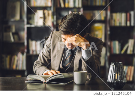執務室・書斎にいる若いアジア人男性ビジネスマン(困る・悩む・難しい・考える) 執務室・書斎にいる若いアジア人男性ビジネスマン(困る・悩む・難しい・考える) 121245104