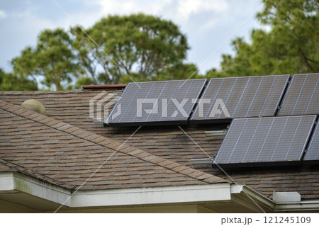 Private home roof covered with solar photovoltaic panels for generating of clean ecological electric energy in suburban rural town area. Concept of autonomous house 121245109
