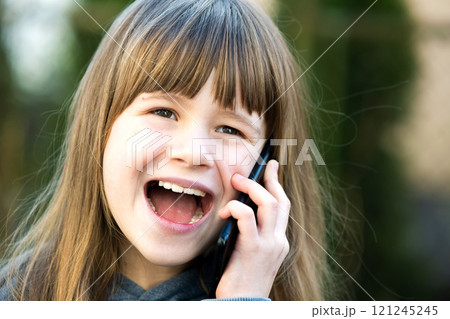 Portrait of pretty child girl with long hair talking on cell phone. Little female kid communicating using smartphone. Children communication concept. 121245245