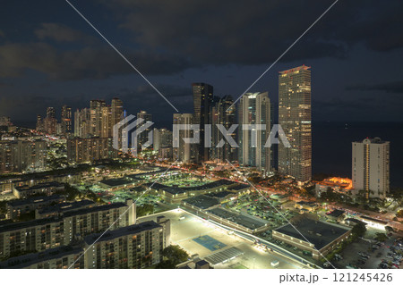 Night urban landscape of downtown district in Sunny Isles Beach city in Florida, USA. Skyline with brightly illuminated high skyscraper buildings in modern american megapolis 121245426