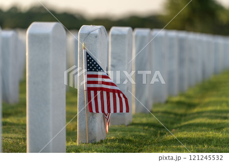 Military burial headstones. Sarasota National Cemetery with rows of white tomb stones and USA flags on green grass. Memorial Day concept Military burial headstones. Sarasota National Cemetery with rows of white tomb stones and USA flags on green grass. Memorial Day concept 121245532