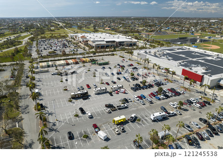 Many parked cars on store parking lot with lines and markings for parking places and directions. Place for vehicles in front of a shopping mall center Many parked cars on store parking lot with lines and markings for parking places and directions. Place for vehicles in front of a shopping mall center 121245538