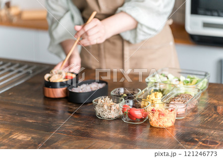 キッチンでお弁当を作る女性の手元 121246773