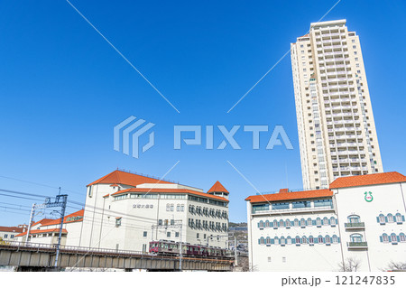 兵庫県宝塚市　快晴の宝塚大劇場と宝塚音楽学校　走行中の阪急電車 121247835