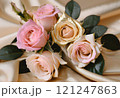 ゴールドのシルクの布の上に置かれたパステルピンクのバラの花束 121247863