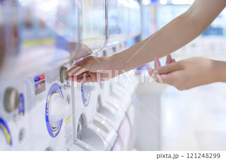 カプセルトイを回す若い女性　ガチャ　トリミングアップ 121248299