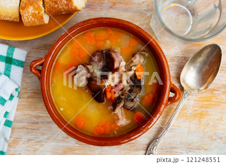 Fragrant pea soup with smoked meats and vegetables in plate 121248551
