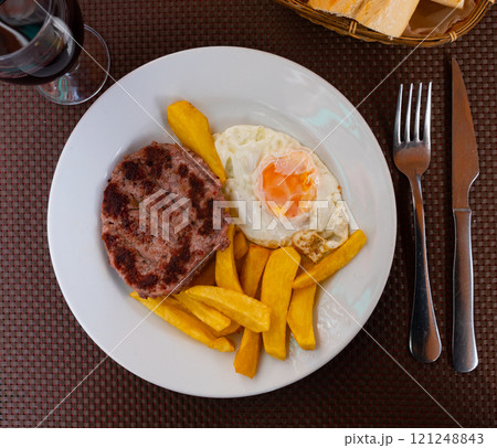 Hamburger patty served with potatoes and egg Hamburger patty served with potatoes and egg 121248843