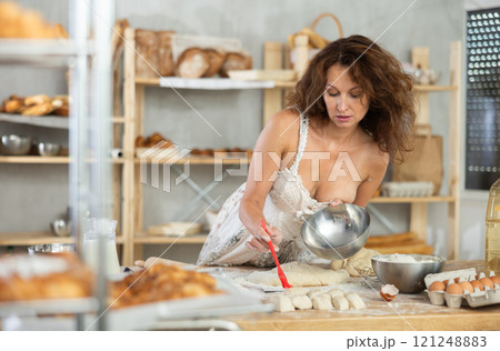 Adult woman in dress greasing dough 121248883