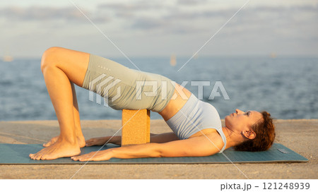 Yoga practice on embankment, female athlete fulfil carry out chatush padasana 121248939
