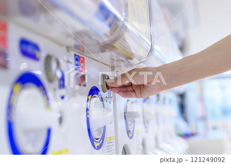 カプセルトイを回す若い女性　ガチャ　トリミングアップ 121249092