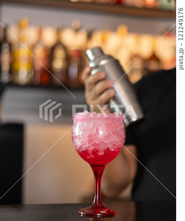 Bartender serving tequila sunrise cocktail at bar Bartender serving tequila sunrise cocktail at bar 121249176
