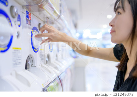 カプセルトイを回す若い女性　ガチャ　 121249378