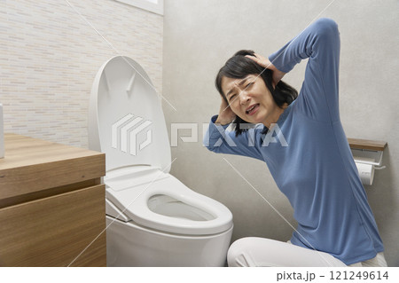 トイレで頭を抱えて困る女性 カメラ目線 トイレで頭を抱えて困る女性 カメラ目線 121249614