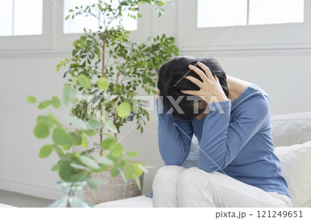 頭を抱えて困る女性　50代　　リビング 121249651