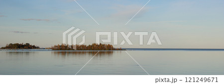 Small island covered by colorful trees and unique horizon line of Lake Vanern, Sweden. Small island covered by colorful trees and unique horizon line of Lake Vanern, Sweden. 121249671