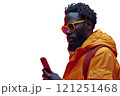 A man in sunglasses and orange jacket checks his phone 121251468