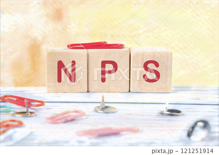 Business concept. Concept word NPS (Net Promoter Score) written on wooden cubes on a yellow background Business concept. Concept word NPS (Net Promoter Score) written on wooden cubes on a yellow background 121251914
