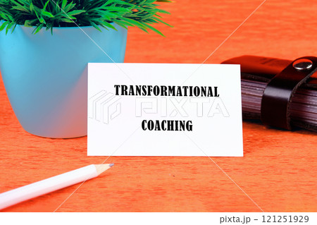 Business, formation or transformation concept. Copy space. TRANSFORMATIONAL COACHING written on a white business card on an orange background 121251929