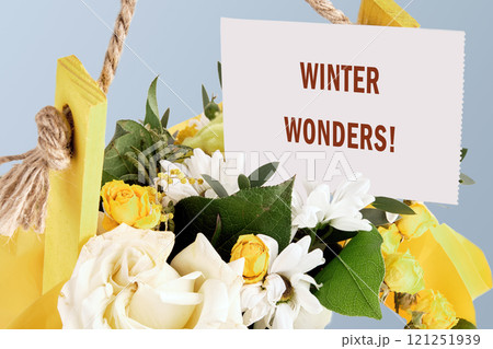 The concept of holidays. The phrase WINTER WONDERS on a white card in a bouquet of flowers 121251939
