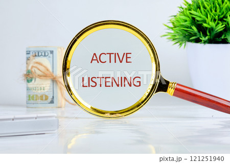 The concept of business and development. Conceptual text, phrase, words ACTIVE LISTENING is written on through a magnifying glass in close-up on a gray background 121251940