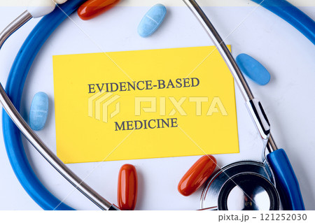 Stethoscope and colorful capsules surrounding evidence based medicine concept on a bright backdrop Stethoscope and colorful capsules surrounding evidence based medicine concept on a bright backdrop 121252030