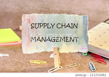 Business concept. SUPPLY CHAIN MANAGEMENT words on a piece of paper in a clothespin Business concept. SUPPLY CHAIN MANAGEMENT words on a piece of paper in a clothespin 121252062