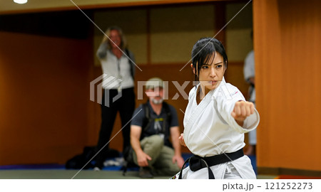 空手道場で見学する外国人の前で空手の技を披露する日本人女性 121252273