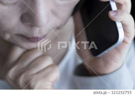 なりすまし電話を受ける高齢女性 スマートホン なりすまし電話を受ける高齢女性 スマートホン 121252755