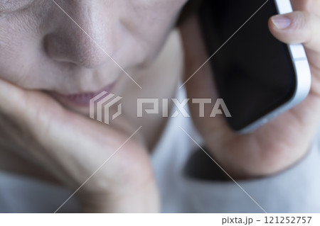 なりすまし電話を受ける高齢女性 スマートホン なりすまし電話を受ける高齢女性 スマートホン 121252757