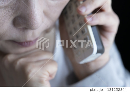 なりすまし電話を受ける高齢女性 固定電話 家電 なりすまし電話を受ける高齢女性 固定電話 家電 121252844
