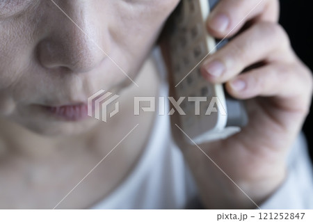 りすまし電話を受ける高齢女性 固定電話 家電 りすまし電話を受ける高齢女性 固定電話 家電 121252847