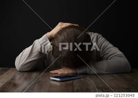 頭を抱え込む女性 スマホ 頭を抱え込む女性 スマホ 121253048