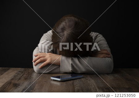 頭を抱え込む女性 スマホ 121253050