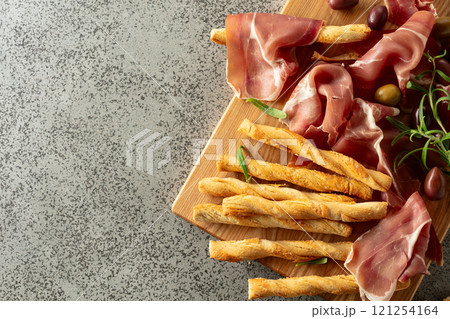 Italian prosciutto with bread sticks, olives, and rosemary. Italian prosciutto with bread sticks, olives, and rosemary. 121254164