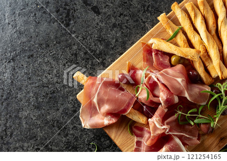 Italian prosciutto with bread sticks, olives, and rosemary. 121254165