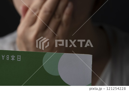 通帳の残高が無くなり呆然とするシニア女性 通帳の残高が無くなり呆然とするシニア女性 121254228