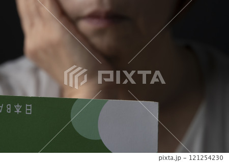 通帳の残高が無くなり呆然とするシニア女性 通帳の残高が無くなり呆然とするシニア女性 121254230