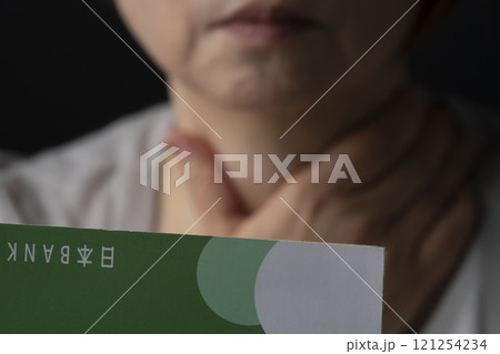 通帳の残高が無くなり呆然とするシニア女性 通帳の残高が無くなり呆然とするシニア女性 121254234