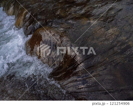 flow water over brown rock. 121254906