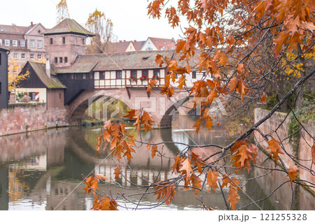 Nuremberg landmark. Medieval houses and bridge over canal with autumn trees. Old town of Nuremberg, Germany. Tranquil autumn landscape in old town. Fall season in historical downtown. Nuremberg landmark. Medieval houses and bridge over canal with autumn trees. Old town of Nuremberg, Germany. Tranquil autumn landscape in old town. Fall season in historical downtown. 121255328
